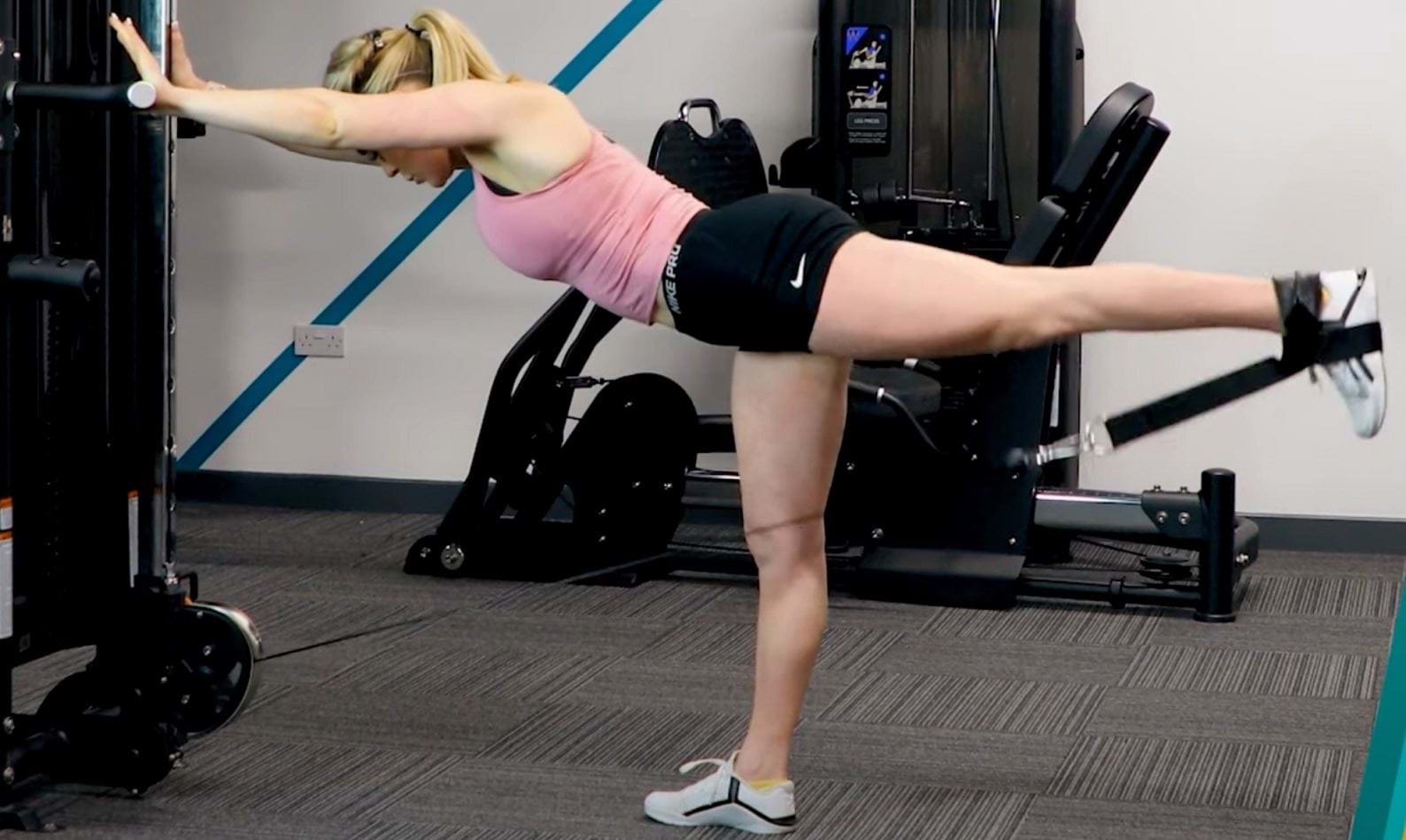 Personal Trainer demonstrating how to do cable kickbacks, a glute focused exercise